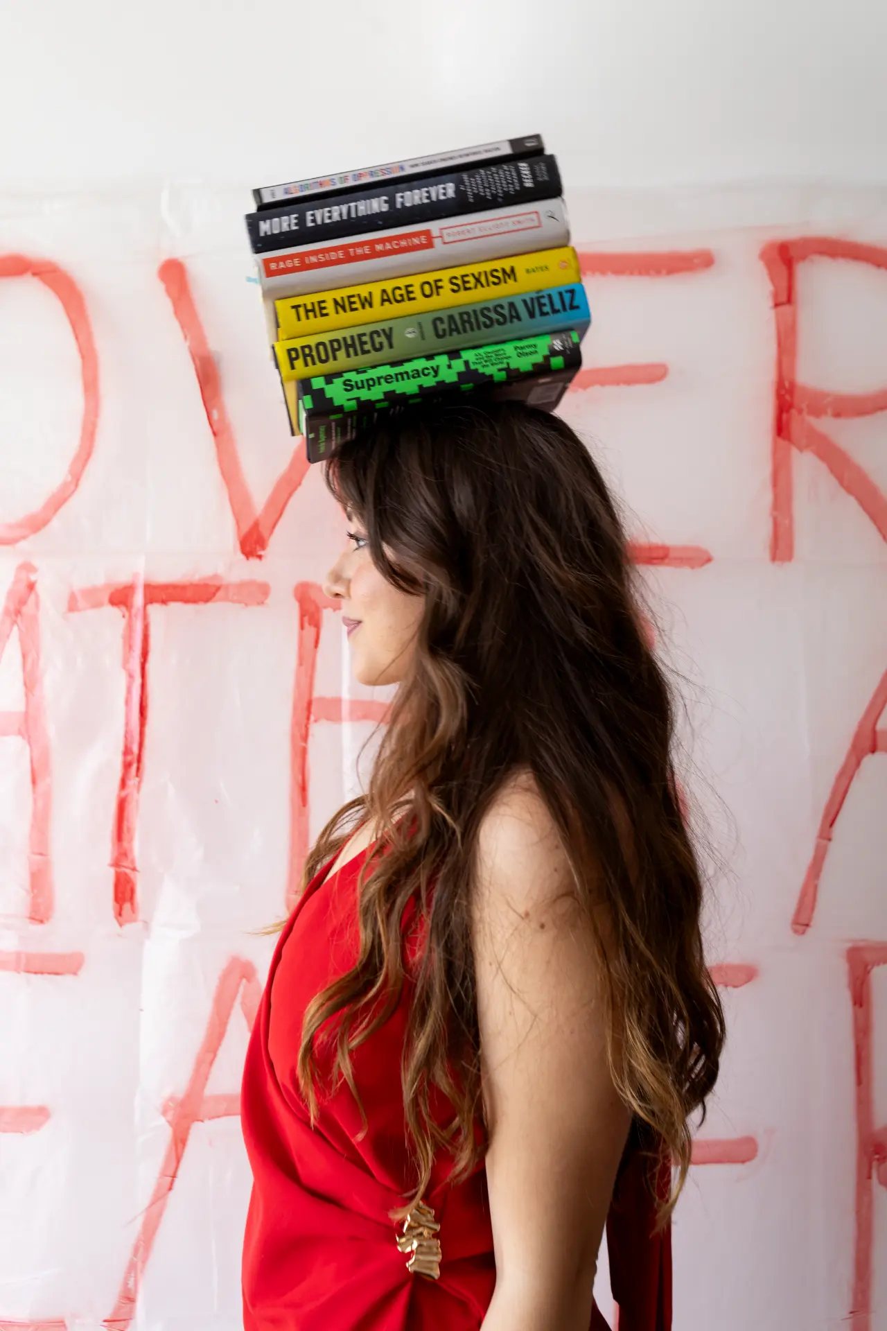 Catharina Doria balancing a stack of AI ethics books on her head