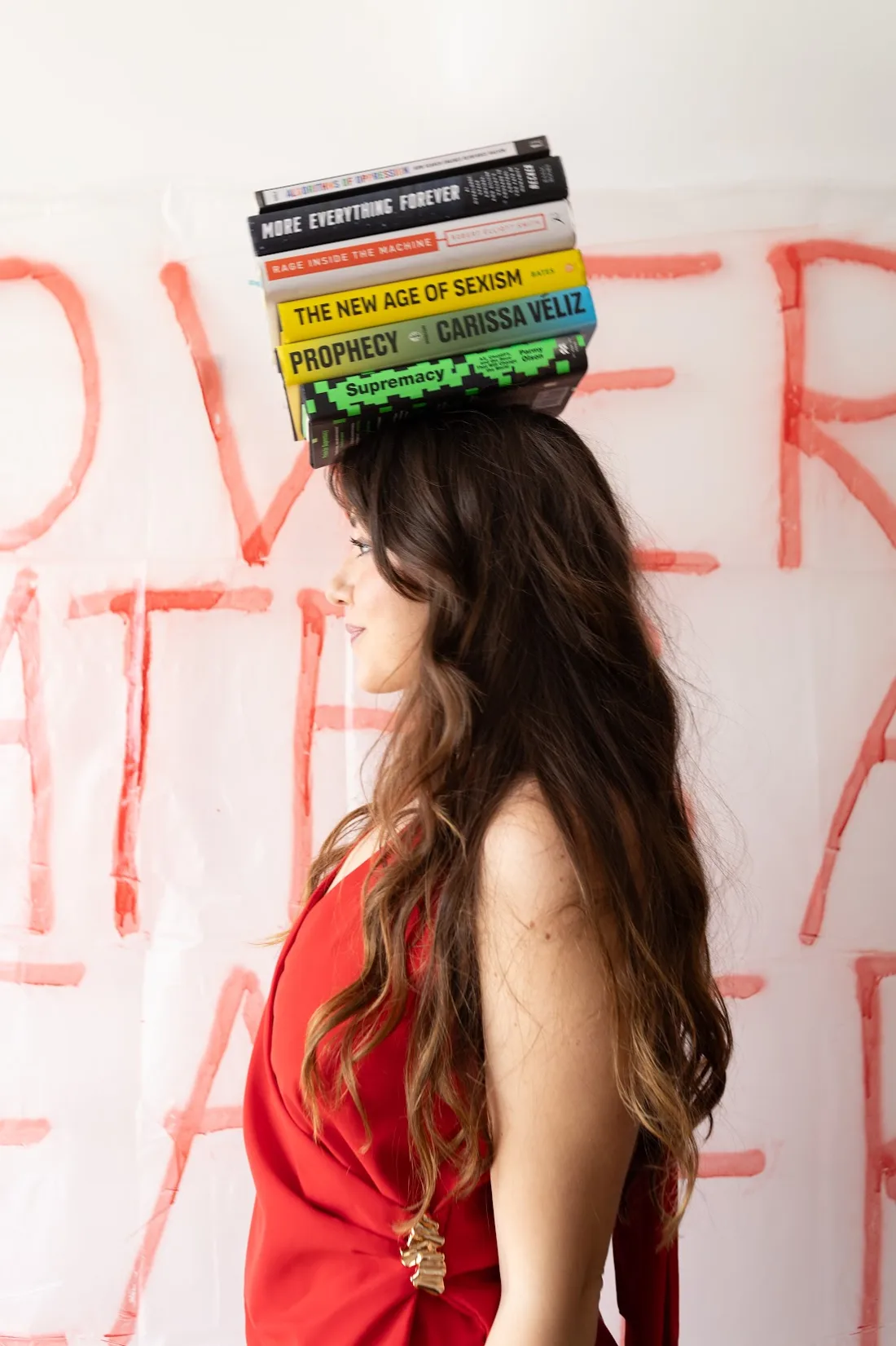 Catharina Doria balancing a stack of AI ethics books on her head